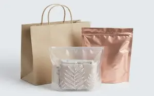 A variety of custom branded packaging including paper shopping bags, resealable Mylar pouches, and poly bags
